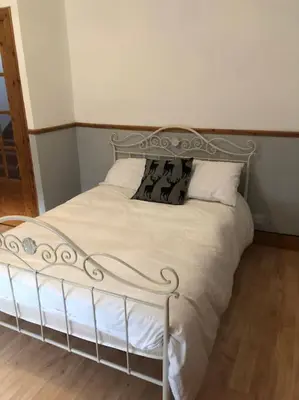 a bed with white sheets and pillows in a room at House in Drymen Village with free local health club access in Glasgow