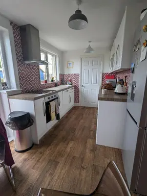 a kitchen with white appliances and a wooden floor at Single room with beautiful garden in Edinburgh