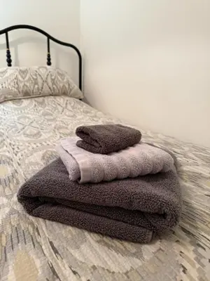 a pile of towels sitting on top of a bed at Single room with beautiful garden in Edinburgh