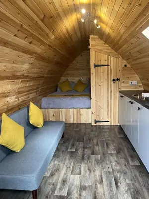 a small room with a bed and a couch in a cabin at Penny gown farm pod in Campbeltown