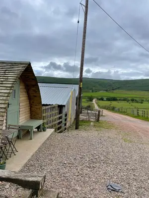 a barn with a bench next to a pole at Penny gown farm pod in Campbeltown