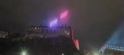 a lit up castle at night with a red light at 223 Websters land - stunning castle view in Edinburgh