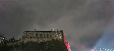 a painting of an old building with a red light at 223 Websters land - stunning castle view in Edinburgh