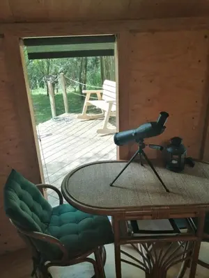 a table with a telescope on it in a cabin at Otter - Eco Bothy with Hot Tub in Castle Douglas