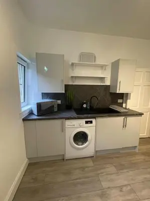 a kitchen with a sink and a washing machine at 2 Bedrooms Holiday home in Edinburgh near City Center in Edinburgh
