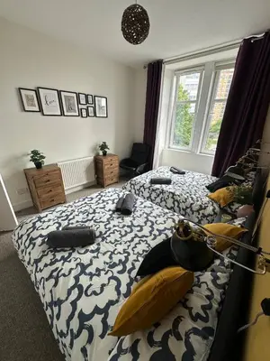 a bedroom with two beds and a window at Clydebank Cozy 3bdr flat near Glasgow in Clydebank