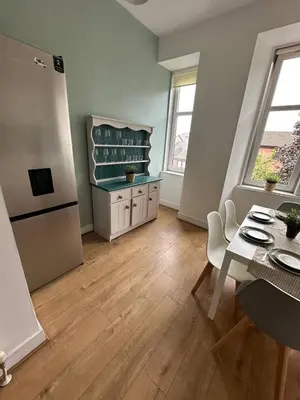 a kitchen with a table and a dining room with a table and a tablektop at Clydebank Cozy 3bdr flat near Glasgow in Clydebank