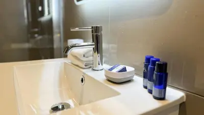 a bathroom sink with a faucet and bottles on it at 19 Snowdon Apartment in Stirling