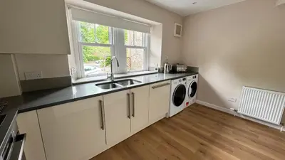 a kitchen with a sink and a washing machine at 19 Snowdon Apartment in Stirling