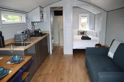 a kitchen and living room with a couch and a bed at Kintyre Glamping Pods in Campbeltown