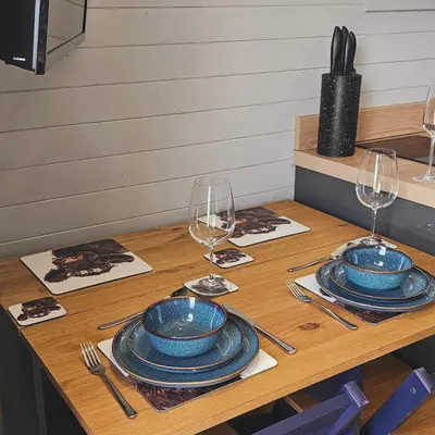 a table with blue plates and wine glasses on it at Kintyre Glamping Pods in Campbeltown