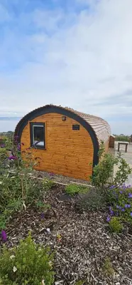 a small wooden building with a window in a yard at Kintyre Glamping Pods in Campbeltown