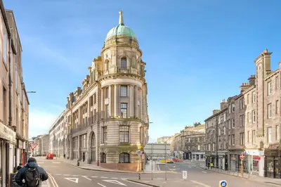 a tall building with a tower on a city street at Two Bedroom Apartment-Central Edinburgh-Old Town-licensed in Edinburgh