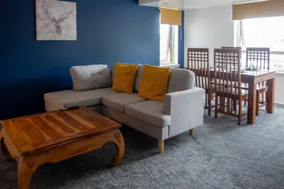 a living room with a couch and a table at 2 Bedroom Beautiful Apartment in Motherwell in Mossend