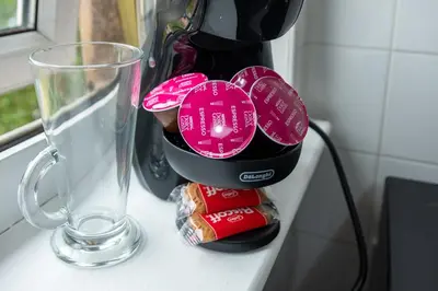 a wine bottle with pink plates on it next to a glass at 2 Bedroom Beautiful Apartment in Motherwell in Mossend