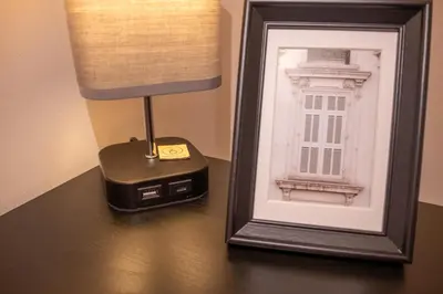 a lamp on a table next to a picture of a building at 2 Bedroom Beautiful Apartment in Motherwell in Mossend