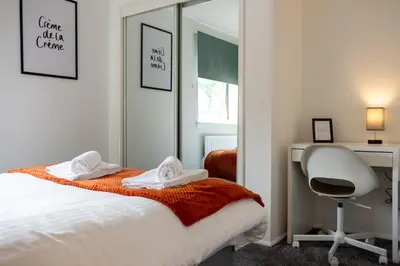 a bedroom with a bed and a desk and a chair at 2 Bedroom Beautiful Apartment in Motherwell in Mossend