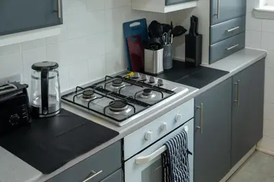 a kitchen with a stove top oven in a kitchen at 2 Bedroom Beautiful Apartment in Motherwell in Mossend