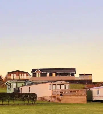 a group of homes in a field with a house at Top Lodge in Newton Stewart