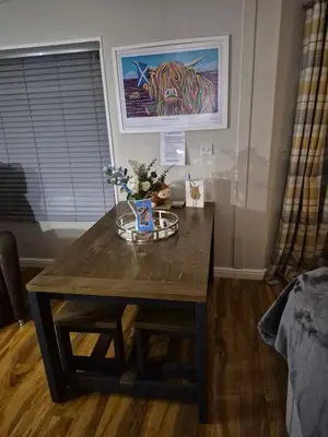 a wooden table with flowers on it in a room at Top Lodge in Newton Stewart