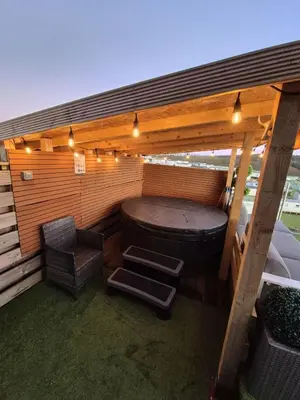 a sauna with a tub and a chair and lights at Top Lodge in Newton Stewart