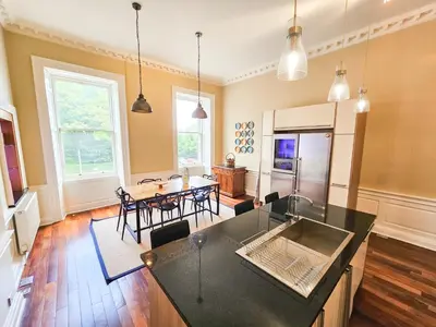 a kitchen and living room with a table and chairs at Spacious 2 Bedroom Apartment in the heart of New Town in Edinburgh