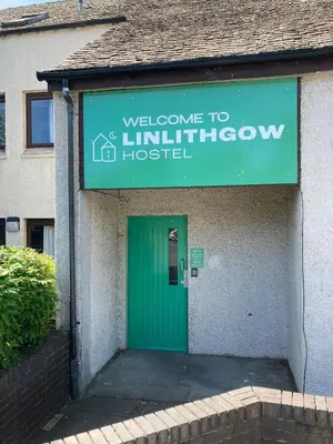 a green door in a building with a sign at Linlithgow Hostel in Linlithgow