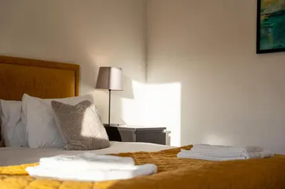 a bedroom with a bed with two towels on it at Aberlour Apartment in Oban