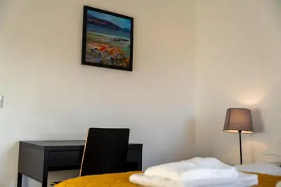 a room with a bed and a desk and a picture on the wall at Aberlour Apartment in Oban