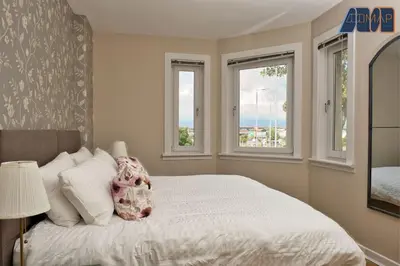 a bedroom with a bed and two windows at Paisley Haven on Renfrew Road in Merksworth