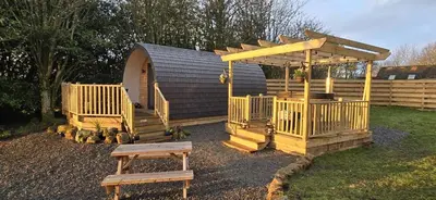 a wooden playground with a gazebo and a bench at The Fells - Campsie Luxury Pods with hot tub in Glasgow