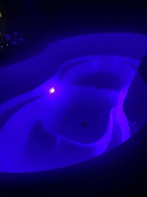 a blue bathtub with a light in the dark at The Fells - Campsie Luxury Pods with hot tub in Glasgow