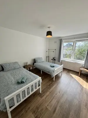 a bedroom with two beds and a window at Seaside Apartment in Helensburgh