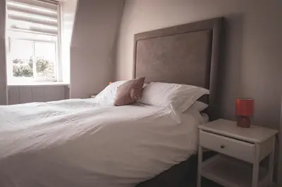 a bedroom with a large white bed with a window at Spacious 4 Bedroom Flat in Stirling in Stirling