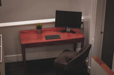 a desk with a computer on it with a chair at Spacious 4 Bedroom Flat in Stirling in Stirling