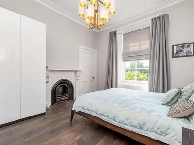 a white bedroom with a bed and a fireplace at Spacious 4 Bedroom Flat in Stirling in Stirling