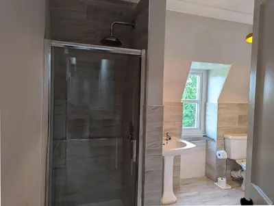a bathroom with a shower and a sink at Spacious 4 Bedroom Flat in Stirling in Stirling