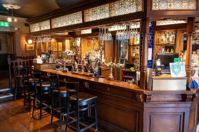 a bar in a pub with stools at Edinburgh Whisky House Hotel in Edinburgh