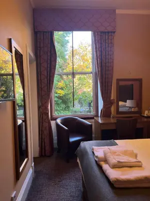 a bedroom with a bed and a large window at Edinburgh Whisky House Hotel in Edinburgh