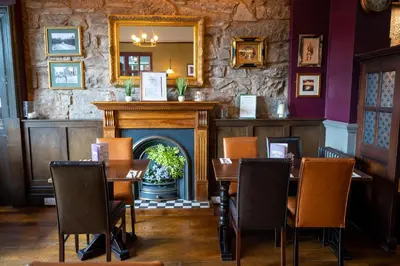 a dining room with a fireplace and tables and chairs at Edinburgh Whisky House Hotel in Edinburgh
