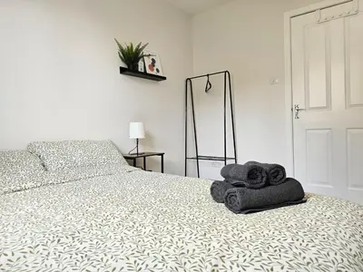 a bedroom with a bed with towels on it at Glasgow Green Modern Stay in Glasgow