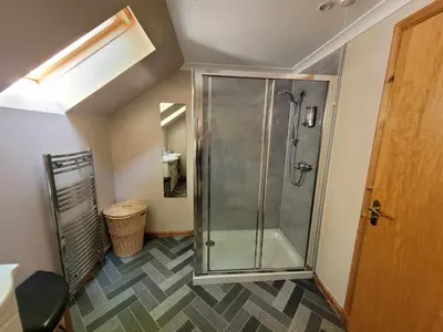 a bathroom with a shower with a glass door at The Steadings in Kinlochleven