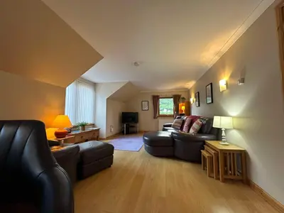a living room with a couch and a table at The Steadings in Kinlochleven