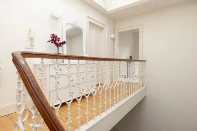 a white staircase in a room with a white wall at JOIVY Exclusive house with free parking in Edinburgh