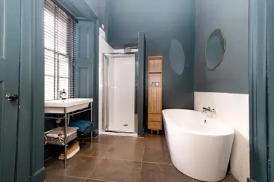 a bathroom with a white tub and a sink at JOIVY Exclusive house with free parking in Edinburgh