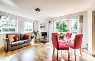 a living room with a couch and a table and chairs at Bright & Modern Flat in Edinburgh