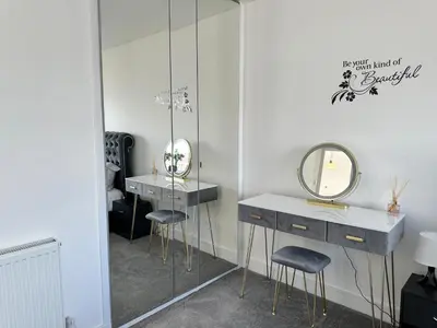 a dressing room with two sinks and a mirror at Elite 3 bedroom family house with free parking in Newton Mearns