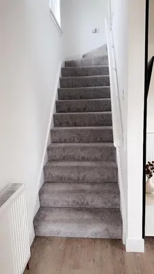 a staircase in a house with grey carpet at Elite 3 bedroom family house with free parking in Newton Mearns