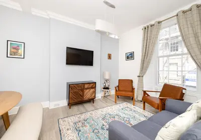 a living room with a couch and a tv at Argyl - Charming 2 Bedroom Apartment on Thistle Street in Edinburgh