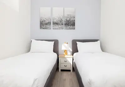 two beds sitting next to each other in a bedroom at Argyl - Charming 2 Bedroom Apartment on Thistle Street in Edinburgh
